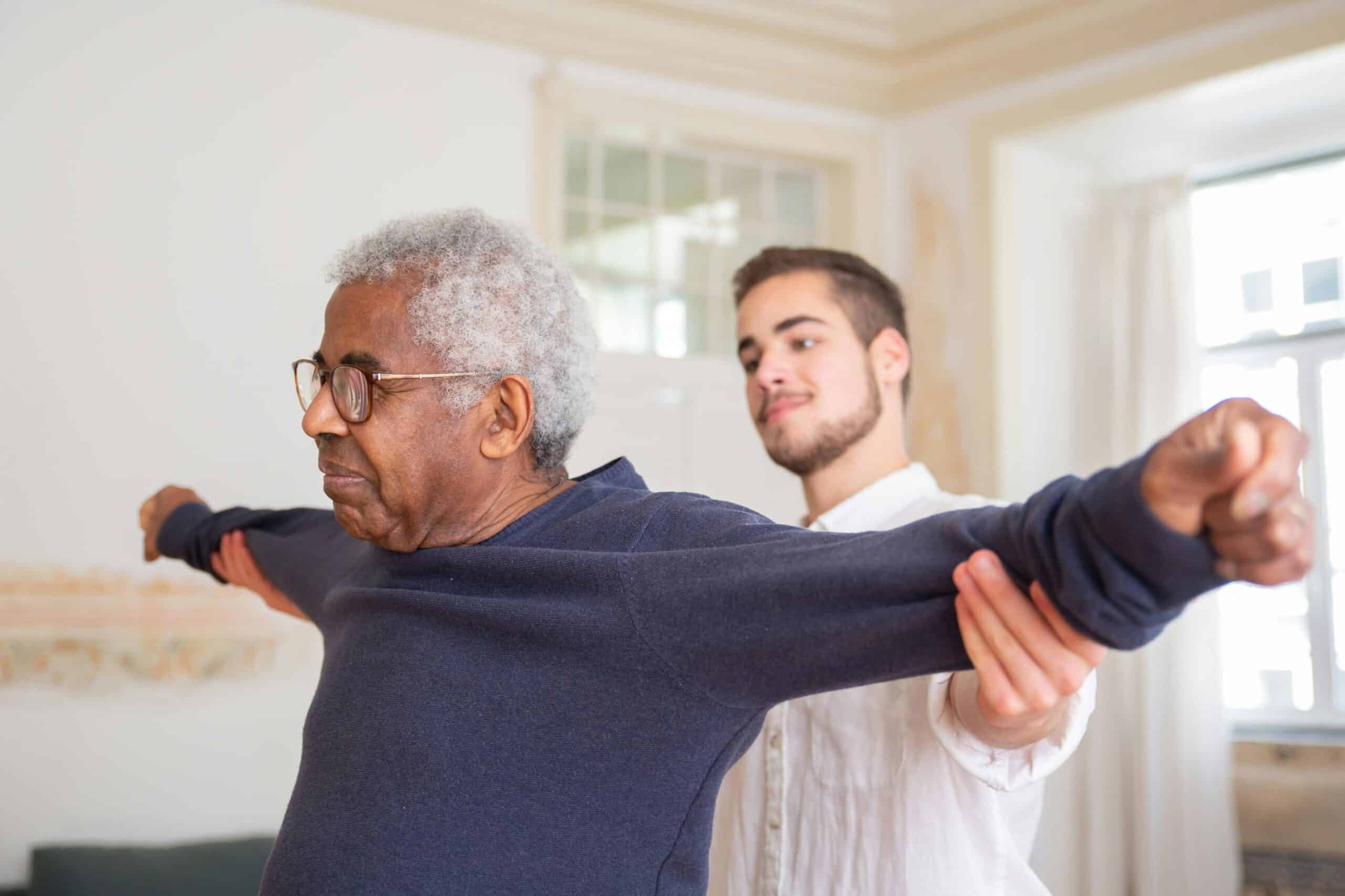 Therapist helping elderly patient stretch arms